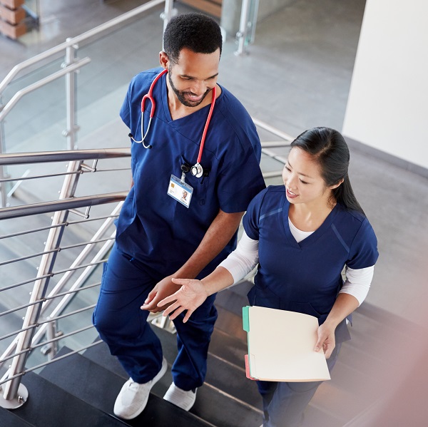 Two nurses climbing stairs and conversing